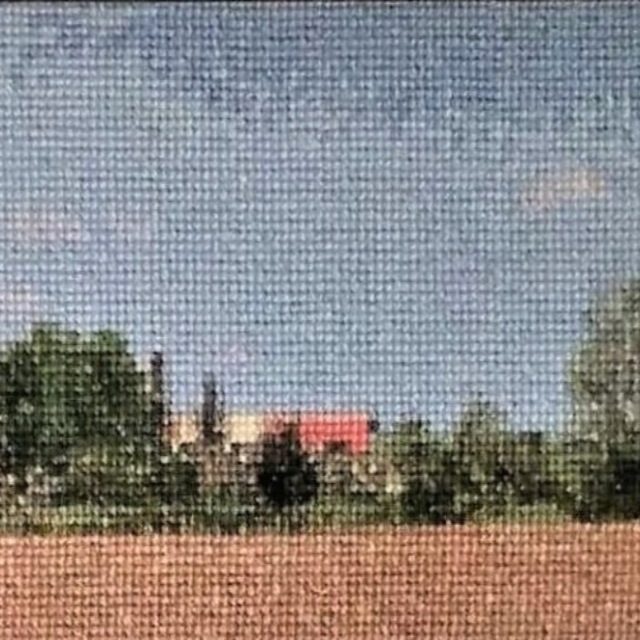 Red Roof, Counted cross stitch on 18ct Aida fabric. Approx. 27 × 10.5 inches framed. The red roof of a barn stands out against a bright sky in late Spring.