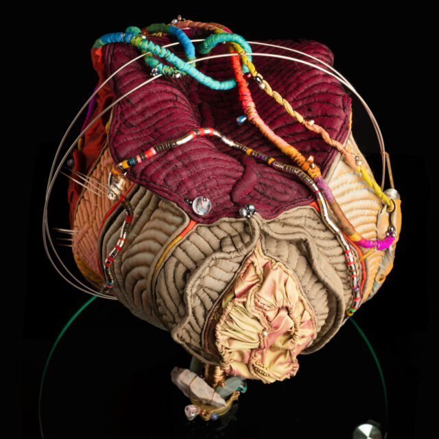 Father of Pearl, 2020, hand stitched quilted silk, silk wrapped string, glass, metal and pearl beads, base strings, porcupine quills, field stones, wrapped copper stem, glass base, 11 x 16 x 12.5 inches (photo:  Nick Menzies)