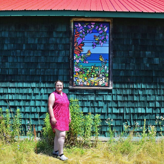 Portia Po Chapman standing with her mural, 