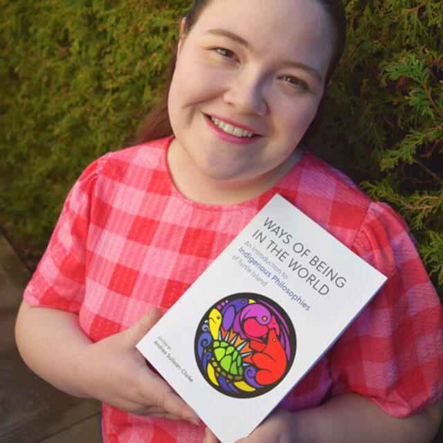 Po holding the Indigenous Philosophy textbook that she illustrated - 2024