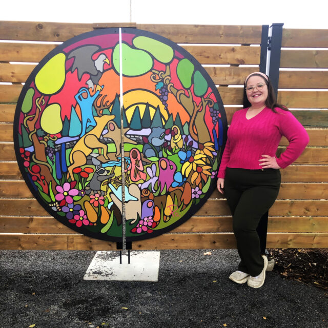 Portia Po Chapman standing with her mural 