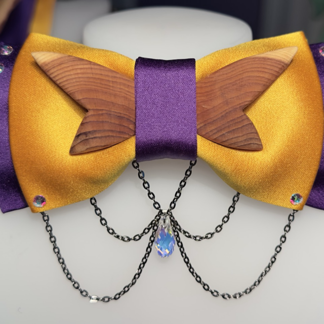 This bow tie was created for a client attending a gala, combining materials to match the client's suit, repurposing wood from a fallen tree, and incorporating Swarovski glass crystals.